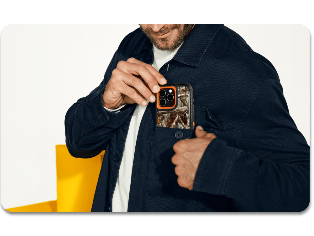 man slipping an iPhone 16 with a Realtree camo case into his pocket